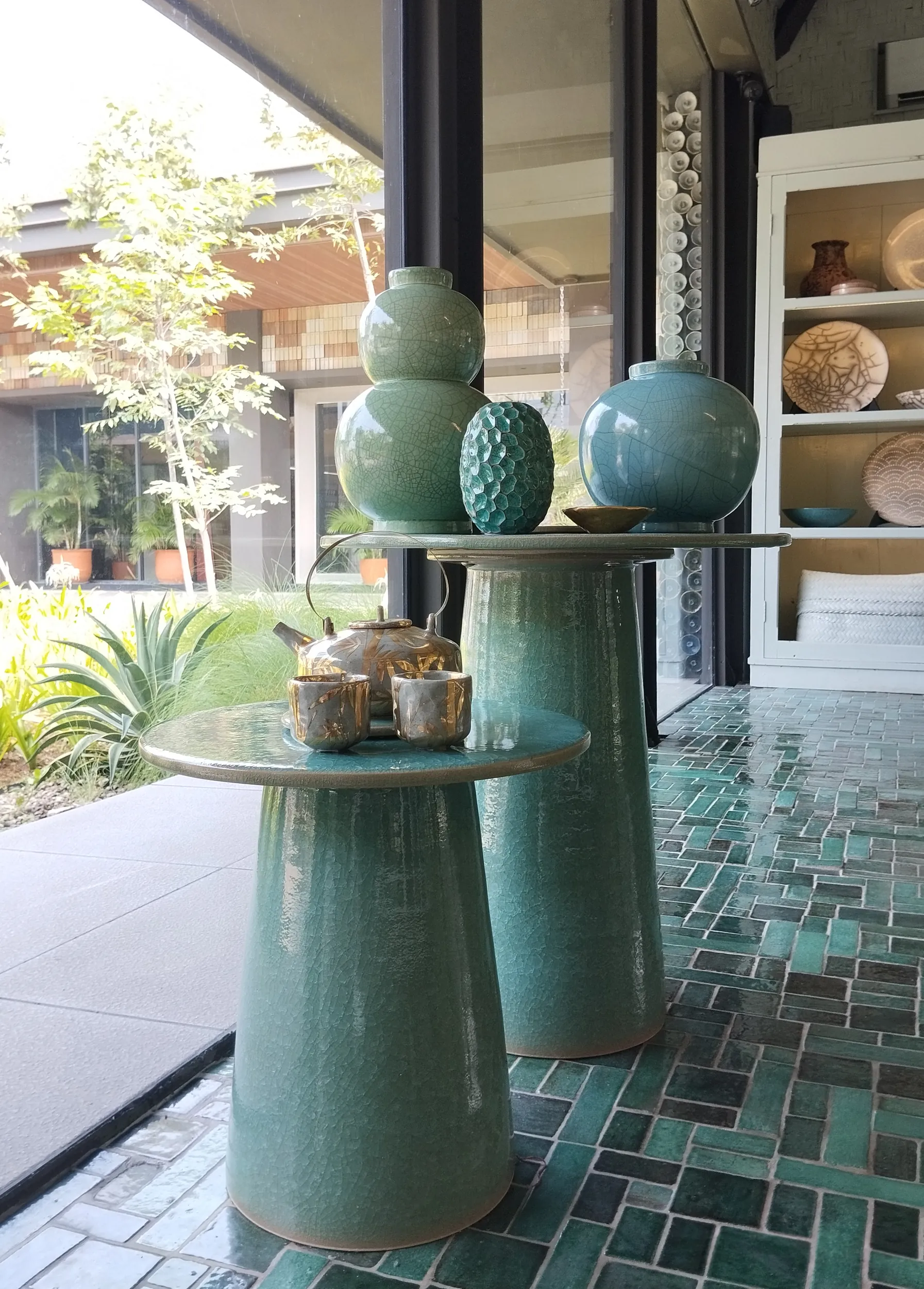 Green ceramics arranged on a pedestal table in the showroom