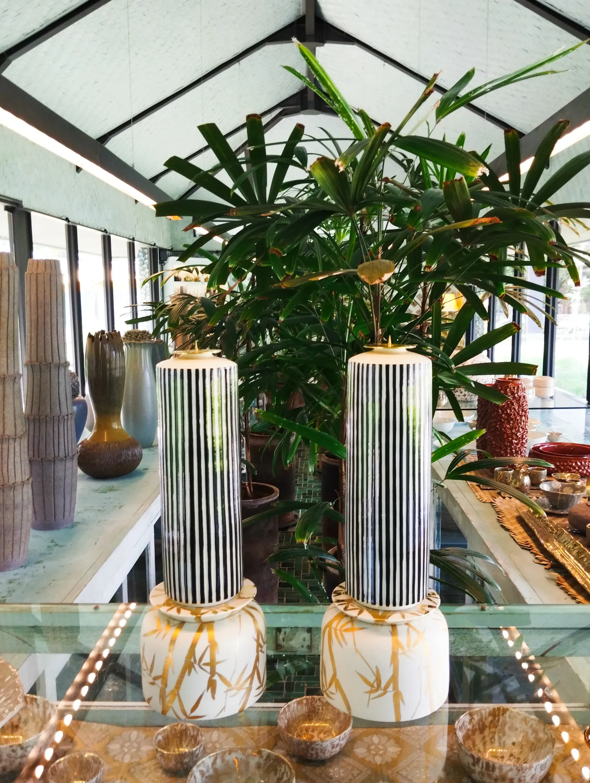 Tall ridged ceramic vases among plants